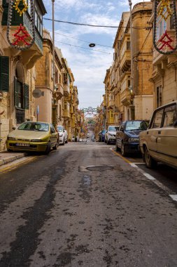 Senglea, Malta - 1 Eylül 2019: Senglea 'da köy ziyafeti için renkli dini ziyafetlerle süslenmiş dar büyüleyici cadde (festa).