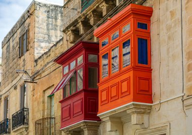 Malta 'nın Cospicua (Bormla) şehrinde kırmızı ve turuncuya boyanmış iki geleneksel ahşap balkon. Otantik Malta şehir sahnesi.