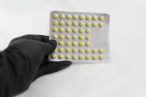 Confezione Pillole Mano Guanto Lattice Nero Concentrazione Selettiva Compresse Rotonde — Foto Stock