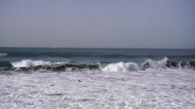 Okyanus sahillerinde örgü ören sörfçüler