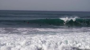 Okyanus sahillerinde örgü ören sörfçüler