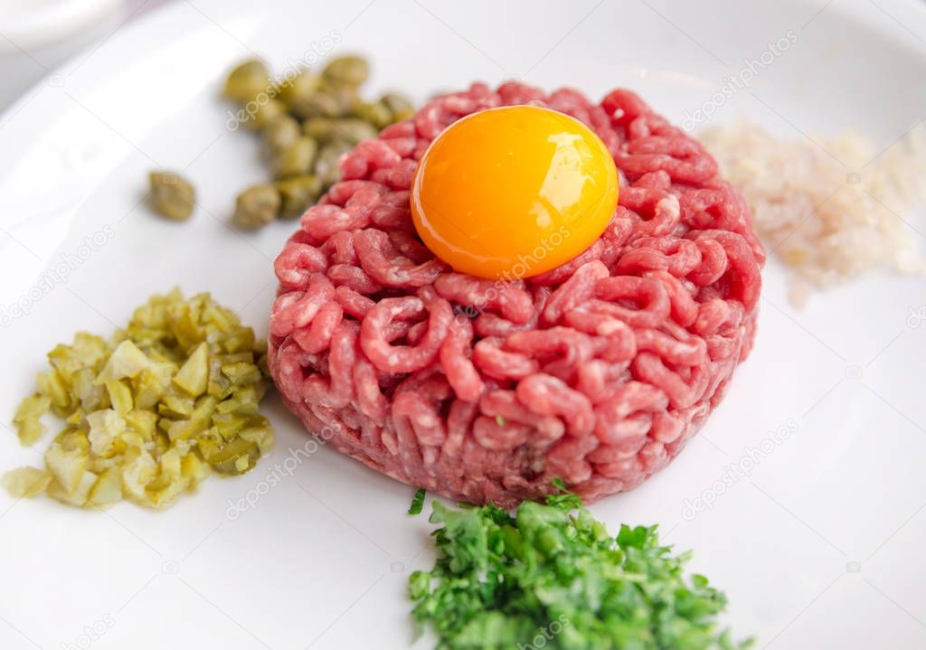 Beef tartare with egg yolk on a white plate, Paris, France