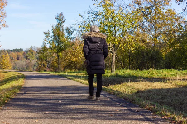 Lady in black on a walkay in fall — Stock Photo, Image