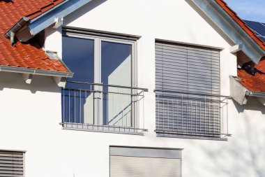 Güney Almanya 'da güneşli bir öğleden sonra, pencereli ve beyaz duvarlı yeni bina cephesi