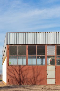 Kahverengi cepheli ve mavi gökyüzü olan eski fabrika binası.