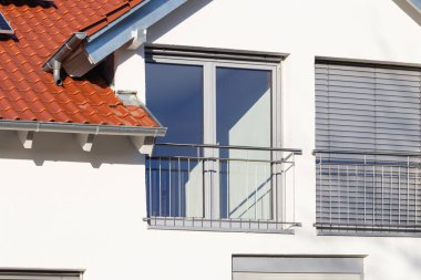 Güney Almanya 'da güneşli bir öğleden sonra, pencereli ve beyaz duvarlı yeni bina cephesi