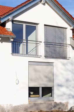 Güney Almanya 'da güneşli bir öğleden sonra, pencereli ve beyaz duvarlı yeni bina cephesi