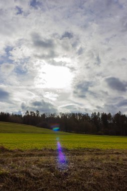 Güney Almanya kırsalında yeşil bir tarlada fırtınalı bulutlu bir gökyüzü