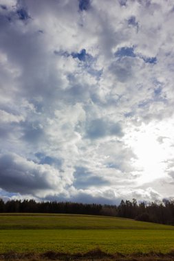Güney Almanya kırsalında yeşil bir tarlada fırtınalı bulutlu bir gökyüzü