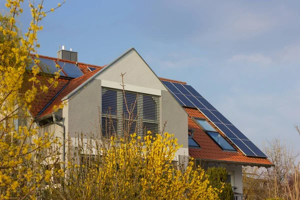 rooftop with solar panels and yellow flowers at south germany springtime sunny day