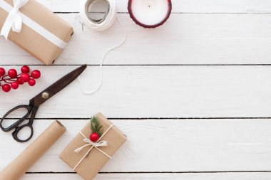 Hediye sarma kompozisyon. El Noel mevcut kutuları dekorasyon ve Beyaz ahşap zemin üzerinde araçları ile hazırlanmış. Düz düzen, üstten görünüm tasarımı. 