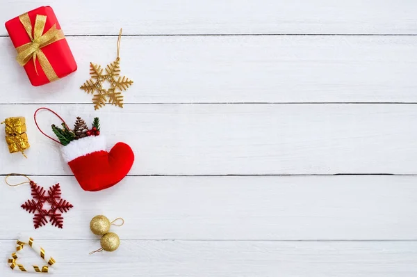 Noel arka plan. Beyaz ahşap tahta üzerinde Noel GIF kutuları, kar tanesi, kırmızı çorap, Noel top ve şeker kamışı. Yaratıcı düz düzen ve üstten görünüm kompozisyon 