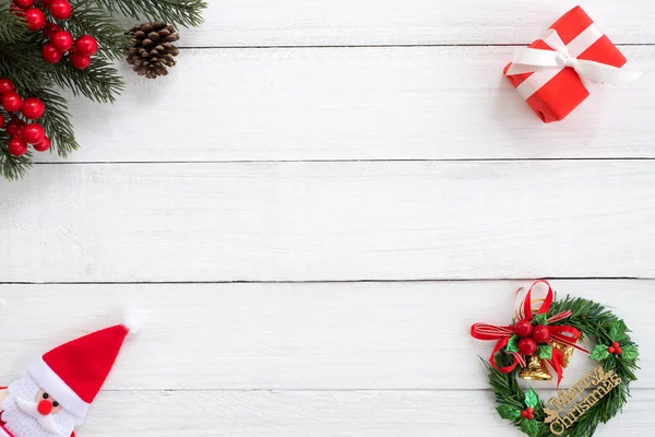 Noel arka plan. Köknar şube, holly berry ve kırmızı hediye kutusu beyaz ahşap tahta üzerinde dekorasyonu ile Noel çerçeve yaptı. Yaratıcı düz yatıyordu, üstten görünüm tasarımı.