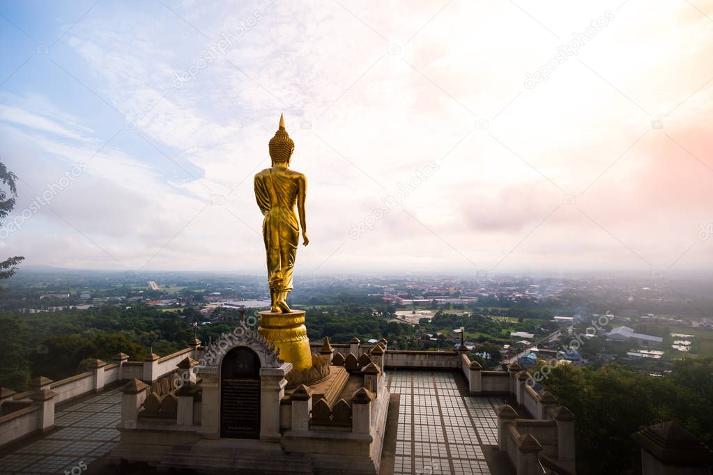 Golden Buddha statue standing on a mountain at Wat Phra That Khao Noi, Nan Province, Thailand 