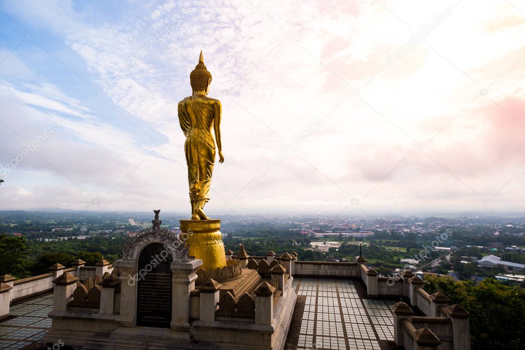 Golden Buddha statue standing on a mountain at Wat Phra That Khao Noi, Nan Province, Thailand 