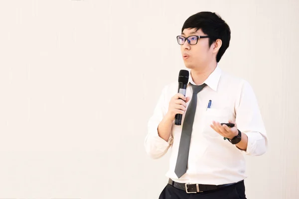 Young male student with black eyeglasses presenting the topic, research in the conference