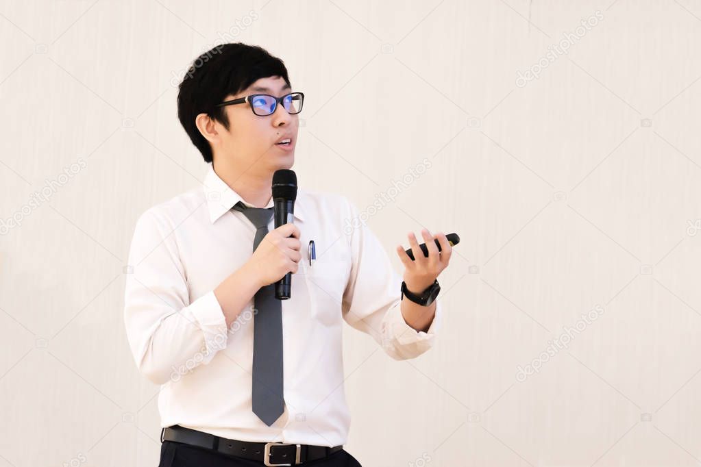 Young male student with black eyeglasses presenting the topic, research in the conference