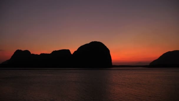 Romántico atardecer púrpura sobre el mar más allá de las montañas — Vídeo de stock