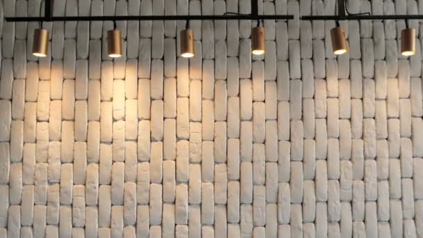 The white brick wall is hilighted with lanterns from above. Background texture — Stock Video