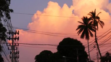 KOH SAMUI ADASI, THAILAND - 10 HAZİRAN 2019: günbatımı tropikal bir gecede turuncu bulutlar. Avuçlar ve elektrik kabloları