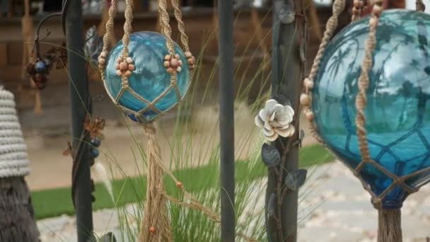 Beautiful retro decor and plants for garden. Set of blue sea buoys from glass and macrame in vintage style for decoration of yard. Modern stylish background. — Stock Video