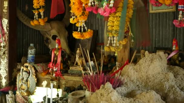 Wooden miniature guardian spirit house. Small buddhist temple shrine, colorful flower garlands. San phra phum erected to bring fortune. Traditional respect animistic rituals, pray ceremonies — Stock Video