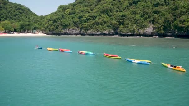 Öar i havet vid Ang Thong National Marine Park nära turistiska Samui paradis tropisk resort. Idyllisk turkos hav naturlig bakgrund med kopia utrymme. Kajaker och färgglada sportkanoter — Stockvideo