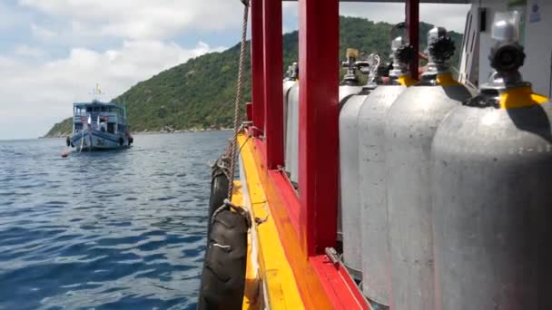 Fila de tanques de oxígeno y equipo de buceo colocado en barco moderno en el océano ondulante cerca de Koh Tao resort, Tailandia. Concepto de deportes turísticos de entretenimiento extremo, aventura y nueva experiencia. — Vídeos de Stock