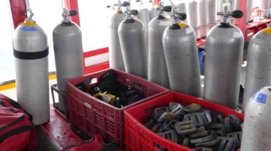 Koh Tao tatil köyü yakınlarındaki dalgalı okyanusta modern bir tekneye yerleştirilmiş oksijen tankları ve dalış ekipmanları. Aşırı eğlence, macera ve yeni deneyim turist sporları kavramı.