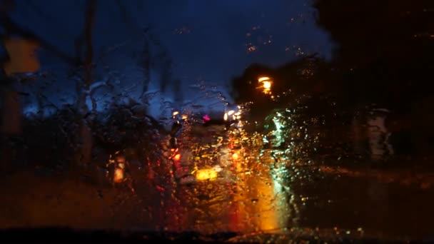 Thajský songthaew bus s osvětlenými světlomety, které cestují noční ulicí během dešťové sezóny. Pohled přes sklo auta v kapkách. Romantický pohled na typickou večerní Asii. Veřejná doprava pod bouřlivým nebem. — Stock video