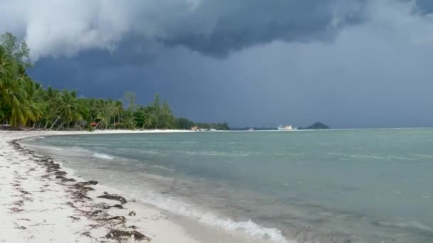 Ondeggiando mare blu, riva sabbiosa dell'isola di Koh Samui durante la stagione delle piogge umide, Thailandia. Uragano e tempeste sulla spiaggia esotica tropicale dell'oceano. Vento forte e nuvole minacciose. Temporale del tifone pericoloso — Video Stock