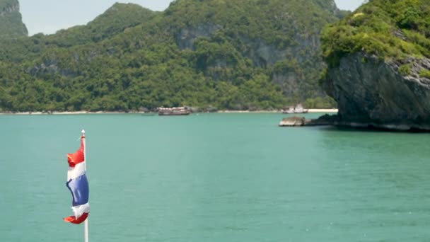 Група островів в океані в національному парку морської піхоти Енг-Тонг. Архіпелаг в Тайській затоці. Ідилічний бірюзовий морський природний фон з копіювальним простором. На човні махають прапором.. — стокове відео