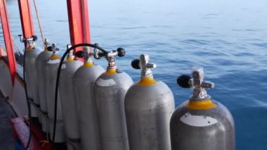 Koh Tao tatil köyü yakınlarındaki dalgalı okyanusta modern bir tekneye yerleştirilmiş oksijen tankları ve dalış ekipmanları. Aşırı eğlence, macera ve yeni deneyim turist sporları kavramı.