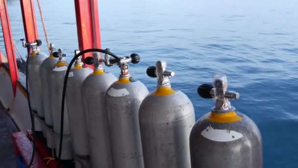 Fila de tanques de oxígeno y equipo de buceo colocado en barco moderno en el océano ondulante cerca de Koh Tao resort, Tailandia. Concepto de deportes turísticos de entretenimiento extremo, aventura y nueva experiencia. — Vídeos de Stock