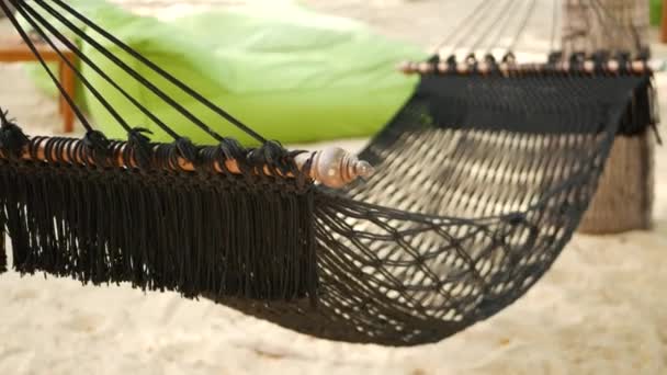 Black hammock stretching between coconut palms. Mesh vintage hipster hammock with fringe on edges stretched on sandy paradise beach of tropical island. Relax, travel vacation holiday resort concept. — Stock Video