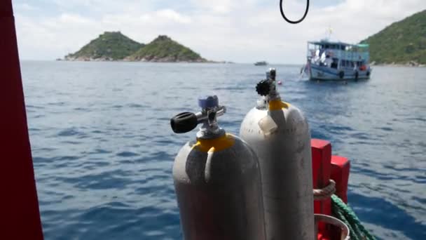 Koh Tao tatil köyü yakınlarındaki dalgalı okyanusta modern bir tekneye yerleştirilmiş oksijen tankları ve dalış ekipmanları. Aşırı eğlence, macera ve yeni deneyim turist sporları kavramı. — Stok video