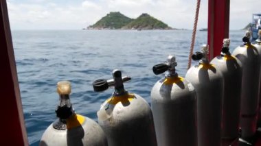 Koh Tao tatil köyü yakınlarındaki dalgalı okyanusta modern bir tekneye yerleştirilmiş oksijen tankları ve dalış ekipmanları. Aşırı eğlence, macera ve yeni deneyim turist sporları kavramı.