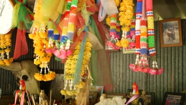 Wooden miniature guardian spirit house. Small buddhist temple shrine, colorful flower garlands. San phra phum erected to bring fortune. Traditional respect animistic rituals, pray ceremonies — Stock Video