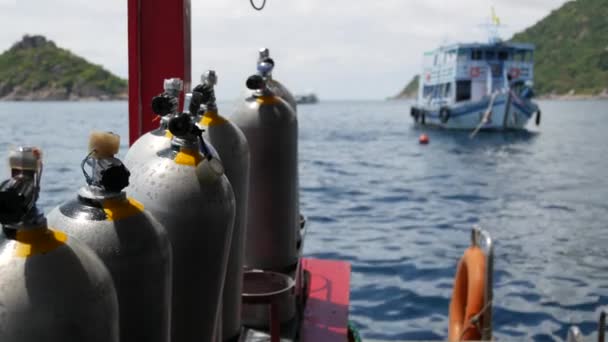 Fila de tanques de oxigênio e equipamento de mergulho colocado em barco moderno em ondulação oceano perto Koh Tao resort, Tailândia. Conceito de esportes turísticos entretenimento extremo, aventura e nova experiência. — Vídeo de Stock