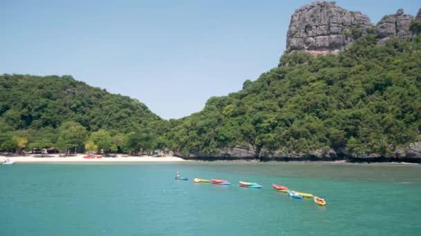Eilanden in de oceaan bij Ang Thong National Marine Park in de buurt van toeristische Samui paradijs tropische badplaats. Idyllische turquoise zee natuurlijke achtergrond met kopieerruimte. Kajaks en kleurrijke sportkano 's — Stockvideo