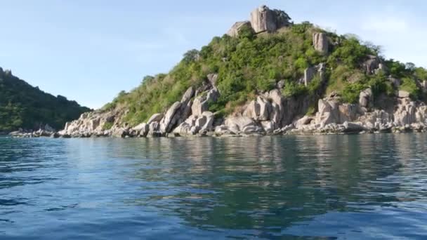 Água calma perto de verde tropical ilha paradisíaca exótica. Tranquilize a água do mar perto do resort de mergulho na ilha verde montanhosa de Tao no dia nublado na Tailândia. Vista do barco. — Vídeo de Stock
