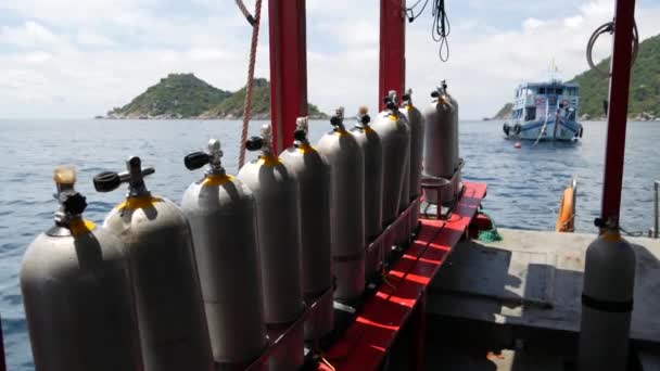 Rij zuurstoftanks en duikuitrusting geplaatst op moderne boot in kabbelende oceaan bij Koh Tao resort, Thailand. Concept van de toeristische sport extreme entertainment, avontuur en nieuwe ervaring. — Stockvideo