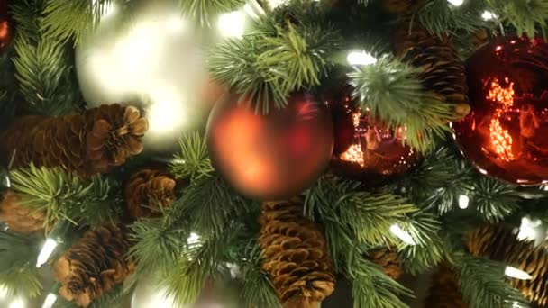 Primo piano di albero di Natale all'aperto festosamente decorato con palline rosso vivo su sfondo fata frizzante sfocato. Luci a ghirlanda sfocate, effetto Bokeh. Buon Natale e Buone Feste concetto. — Video Stock