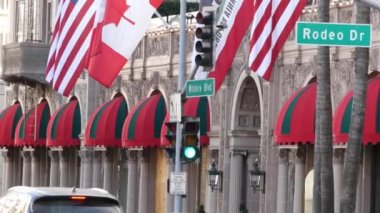 Beverly Hills 'te Amerika Birleşik Devletleri bayrağına karşı dünyaca ünlü Rodeo Drive Street tabelası. Los Angeles, Kaliforniya, ABD. Zengin zengin yaşam tüketiciliği, lüks markalar, yüksek sınıf mağazalar konsepti.