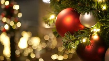 Neşeli Açık Hava Noel Ağacı 'nın yakın çekimleri. Peri arka planında parlak kırmızı toplar var. Odaklanmamış çelenk ışıkları, Bokeh etkisi. Mutlu Noeller ve Mutlu Noeller konsepti.