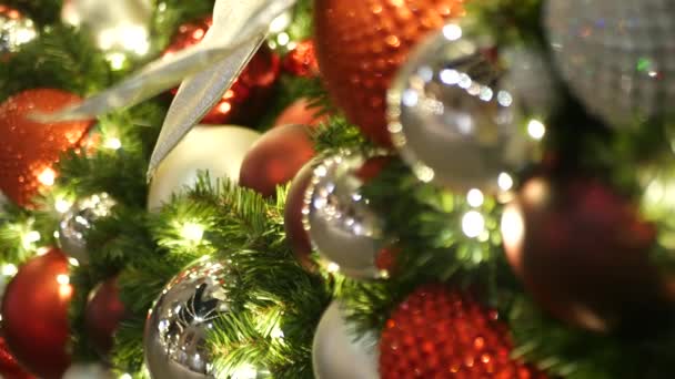 Closeup of Festively Decorated Outdoor Christmas tree with bright red balls on blurred sparkling fairy background. Defocused garland lights, Bokeh effect. Merry Christmas and Happy Holidays concept. — Stock Video