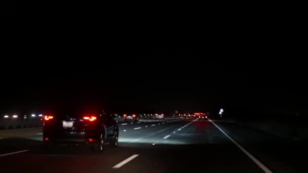 Widok z samochodu. Los Angeles jest zajęte autostradą w nocy. Massive Interstate Highway Road w Kalifornii, USA. Automatyczna jazda po drogach ekspresowych. Koncepcja korków i transportu miejskiego. — Wideo stockowe