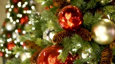 Neşeli Açık Hava Noel Ağacı 'nın yakın çekimleri. Peri arka planında parlak kırmızı toplar var. Odaklanmamış çelenk ışıkları, Bokeh etkisi. Mutlu Noeller ve Mutlu Noeller konsepti.