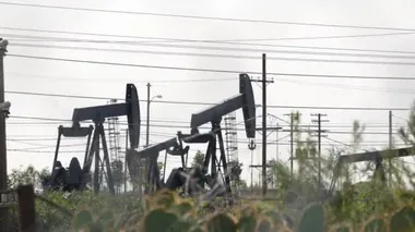 Endüstriyel şehir manzarası. La Brea Inglewood, Los Angeles 'ta. Çitin arkasında Jack 'i pompala. Sondaj kulesi ham petrol çıkarıyor. Çalışan pistonlu bir yağ makinası. Petrol ve doğalgaz endüstrisi