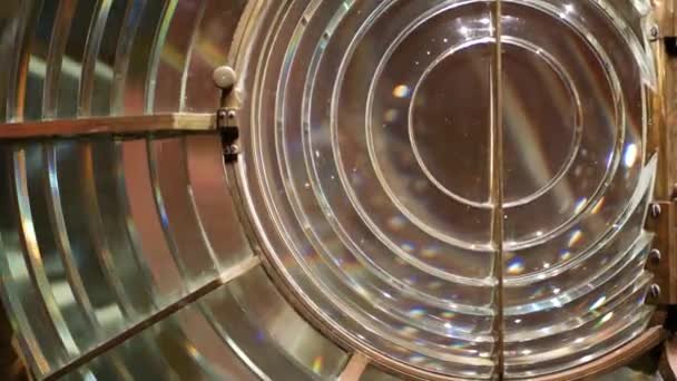 Fresnel lens with brass structure, nautical lighthouse tower. Detail of the glass lantern with rainbow spectrum. System of lamps and lenses to serve as a navigational aid. Old sea searchlight beacon. — Stock Video